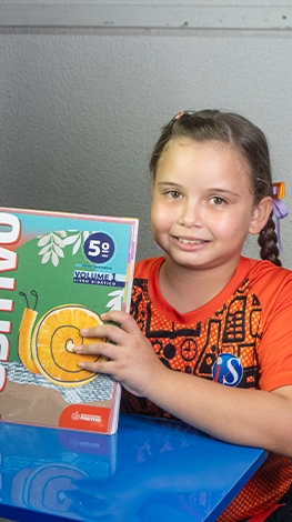 Aluna mostrando seu livro didático